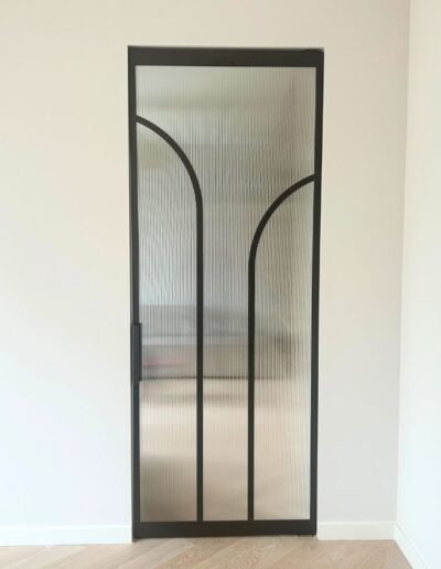 Ronde stalen taatsdeur in Metallic Brown met geribbeld glas en organische boogvorm