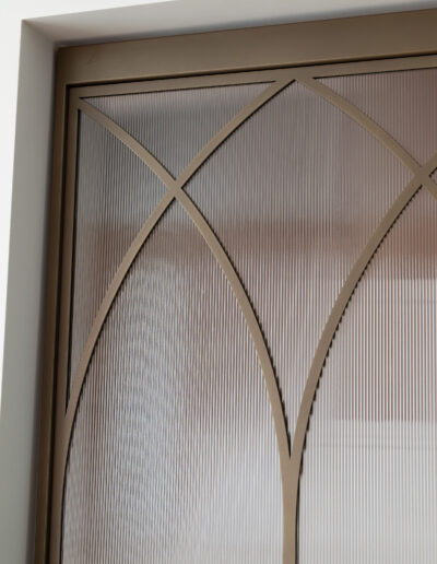 Skygate Flow detail van stalen deur met ribglas en bronzen bogen in metallic bonded bronze afwerking