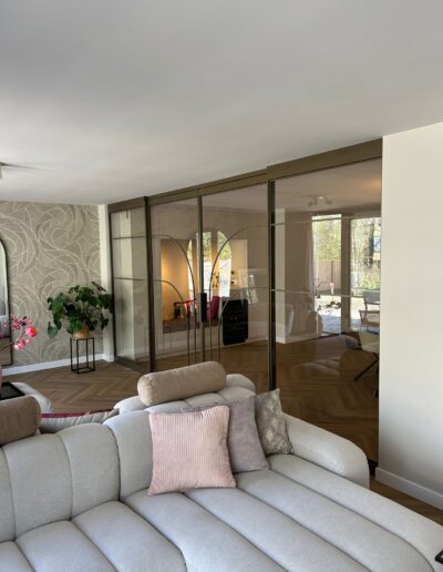 Skygate stalen schuifpui in metallic brons met helder glas en organische profielen, stijlvolle verbinding in de woonkamer.