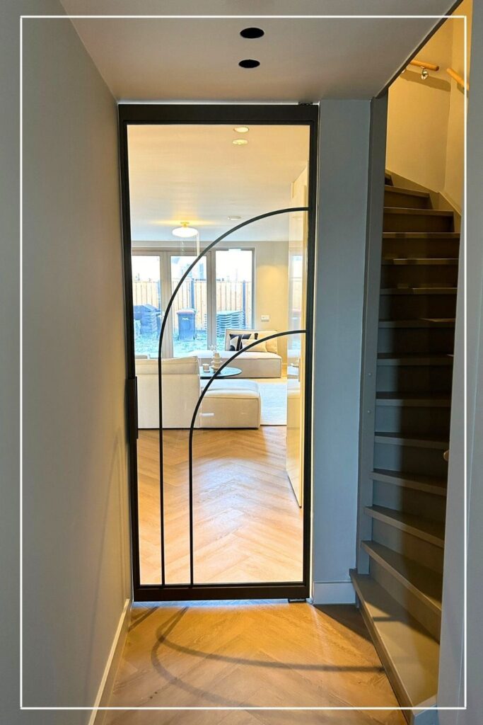 Maatwerk ronde stalen deur van Skygate – Flow model 11 in brons, design stalen deur met glas voor de gang.