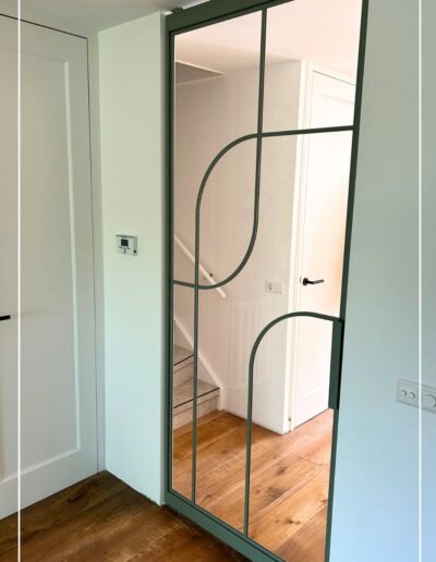 Maatwerk stalen deur van Skygate in groene RAL-kleur – uniek design met symbolische betekenis tussen hal en woonkamer, stalen deur met glas op maat