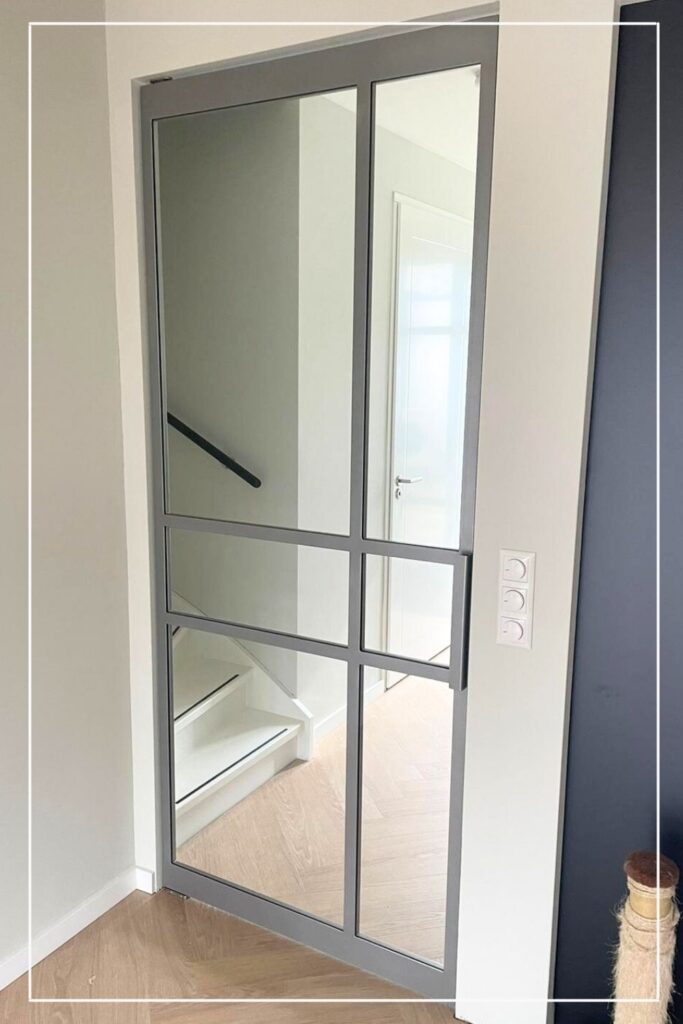 Maatwerk lichtgrijze stalen taatsdeur van Skygate – model 8 met glas, design stalen deur tussen hal en gang in moderne stijl.