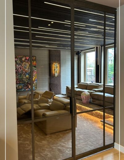 Skygate dubbele schuifdeur in edel brons toegepast in een thuisbioscoop, maatwerk