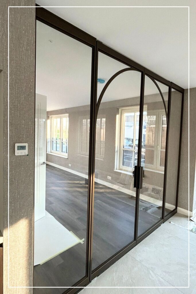 Skygate stalen roomdivider met taatsdeur in metallic bonded bronze en helder glas, maatwerk