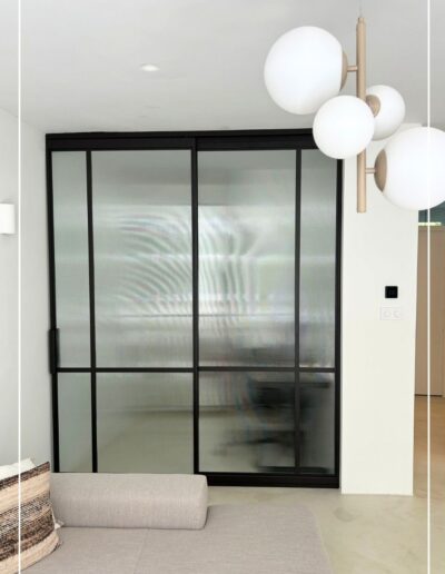 Skygate enkele stalen schuifdeur met ribbelglas en vast zijpaneel, modern maatwerkdesign.