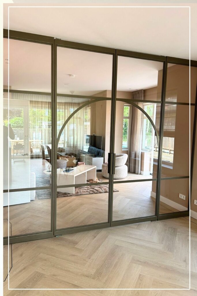 Skygate bronzen stalen schuifpui met glas, Classic model, als elegante scheiding tussen woonkamer en eetkamer.
