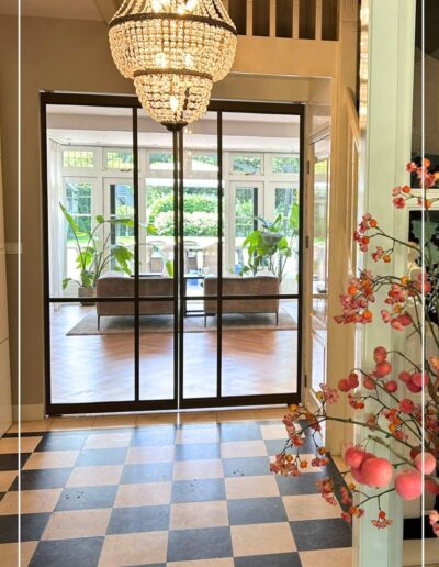Skygate dubbele stalen taatsdeuren tussen hal en woonkamer, strak maatwerkdesign met glas.