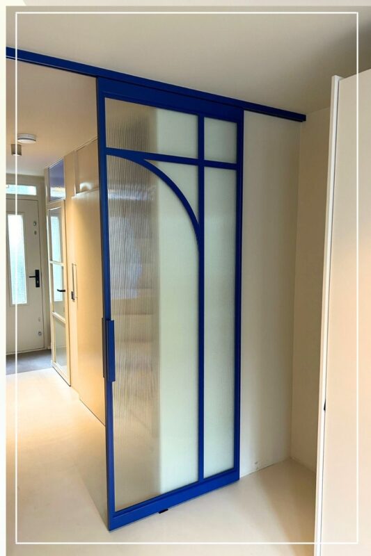 Skygate Flow – stalen schuifdeur in RAL-blauw met ribbelglas