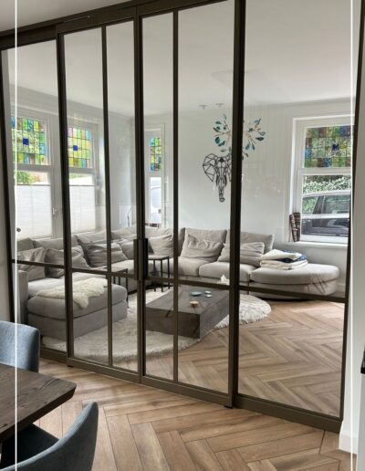 Skygate maatwerk stalen schuifpui in bonded brons, elegante verbinding tussen woonkamer en eetkamer.