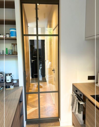 Skygate enkele schuifdeur met helder glas, maatwerk uitgevoerd met Metallic afwerking tussen keuken en woonkamer.
