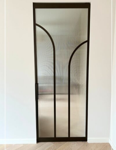 Skygate Flow taatsdeur in RAL zwart met ribbelglas