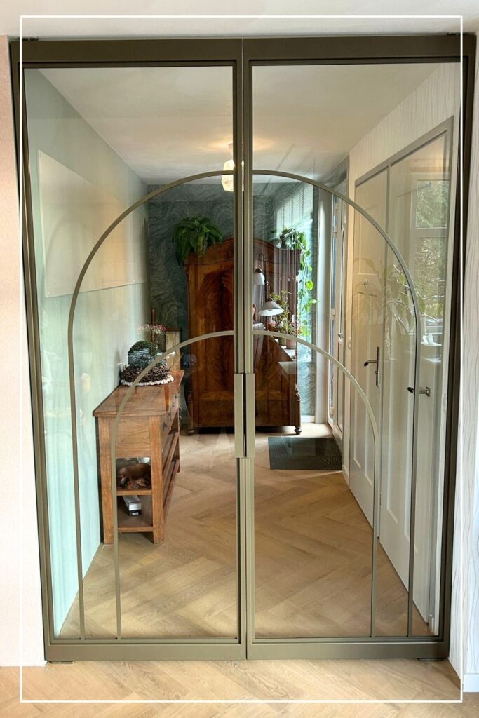 Skygate Flow symmetrische dubbele taatsdeuren met organische profielen en glas, geplaatst in een gang.