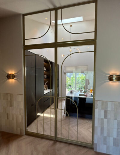 Skygate dubbele gouden taatsdeuren in Metallic afwerking met helder glas en bovenlicht, maatwerk custom design.