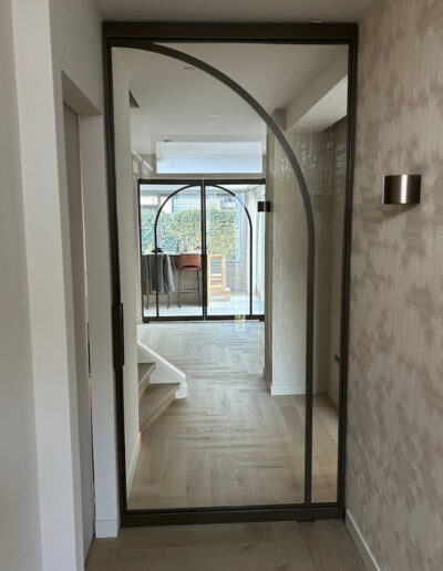 Skygate enkele taatsdeur in eigen Flow-ontwerp, maatwerk met helder glas en Metallic afwerking tussen hal, woonkamer en keuken.