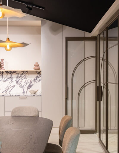 Skygate taatsdeuren in wand, Flow-design in Bonded Brons Metallic met helder glas en slanke profielen.