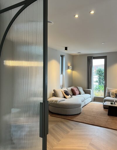 Skygate taatsdeur met geribbeld glas en woonkamer op de achtergrond