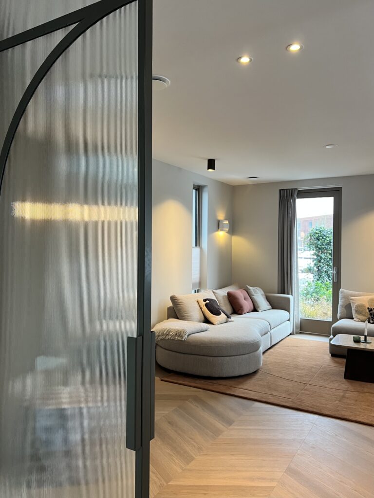 Skygate taatsdeur met geribbeld glas en woonkamer op de achtergrond