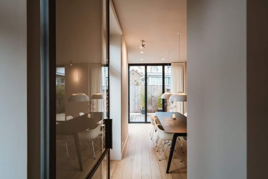 doorkijk woonkamer met Skygate stalen deur met glas en taatsdeur op maat