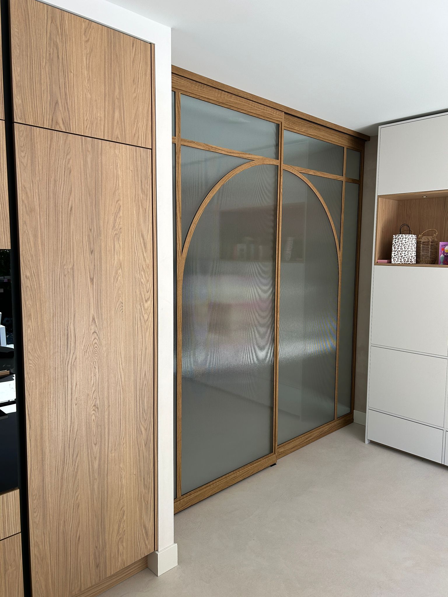 Skygate houtlook schuifpui als roomdivider in de keuken met ribglas en ronde vorm.