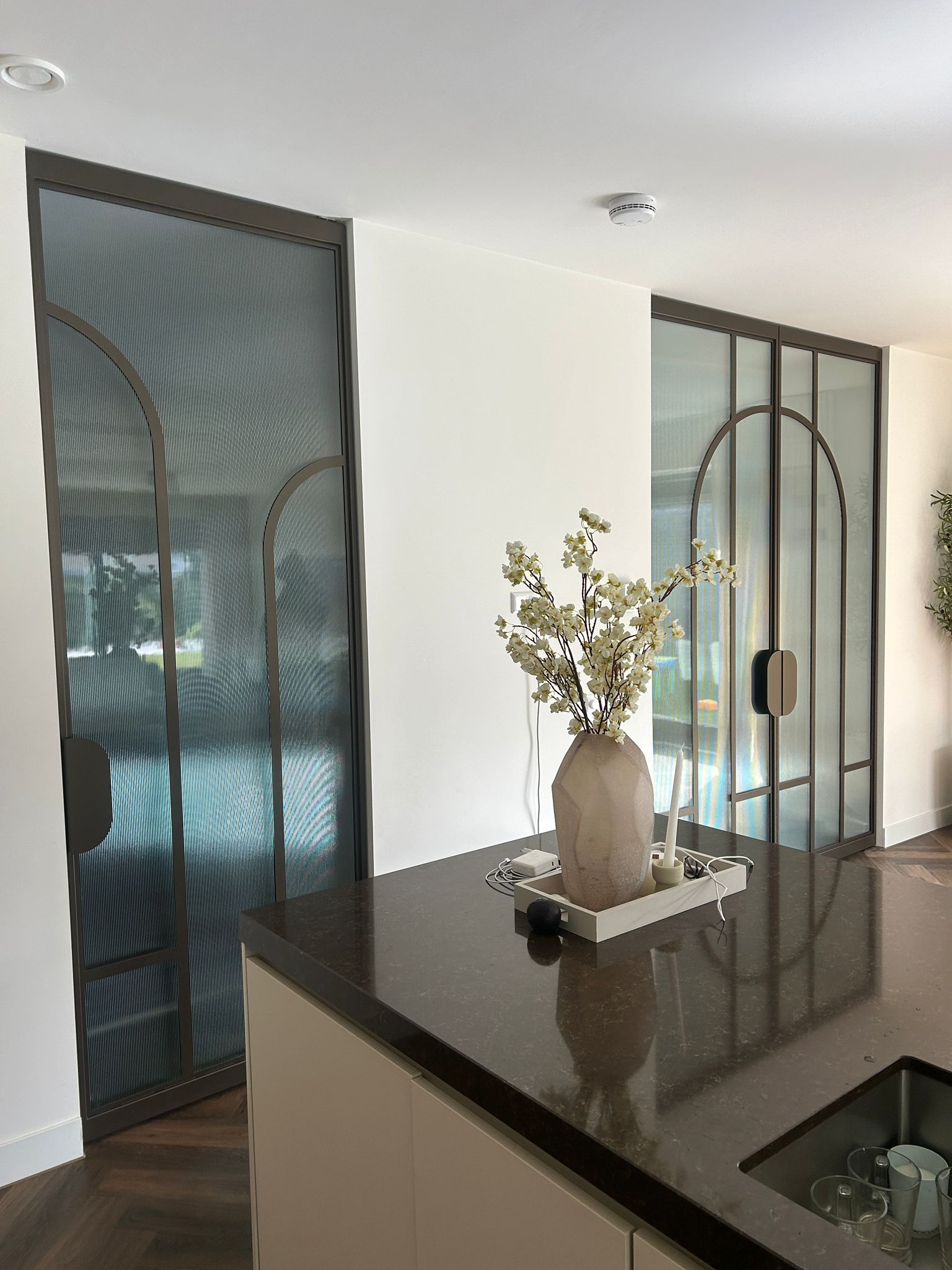 Skygate stalen taatsdeuren op maat in metallic brown met ribglas en organisch Flow design in interieur.