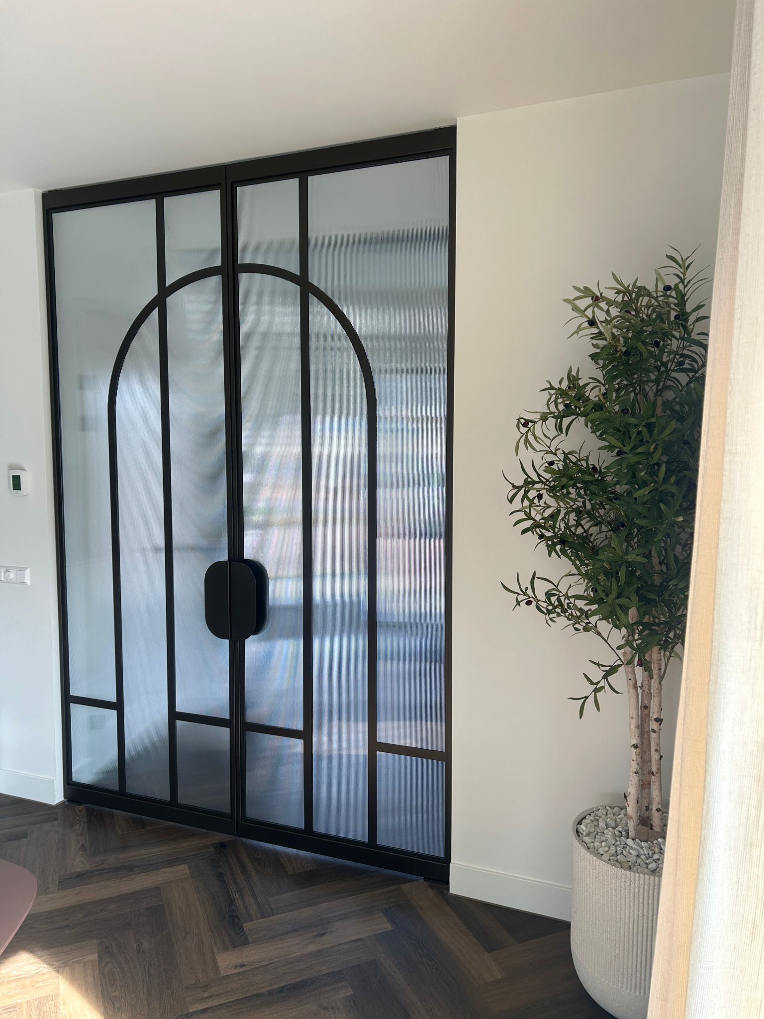 Skygate taatsdeur op maat in metallic brown met ribglas en Flow design bij houten vloer