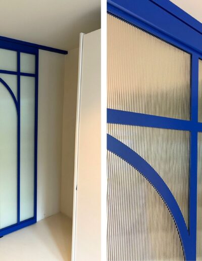 Blauwe stalen schuifdeur met ronde boog en ribbelglas van Skygate