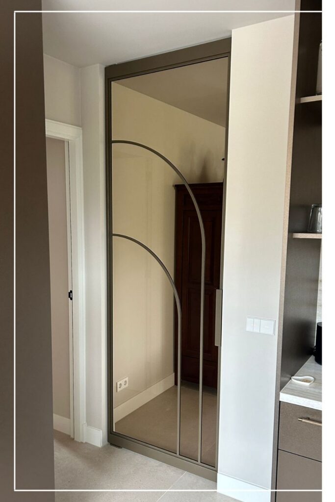 Hoge stalen taatsdeur in Metallic Brons met Flow design No. 11 en brons glas van Skygate in een modern interieur