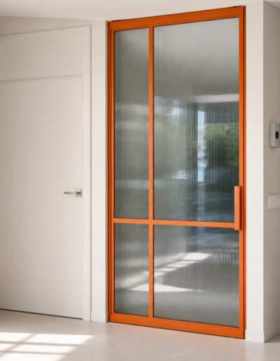 Oranje stalen taatsdeur met ribbelglas