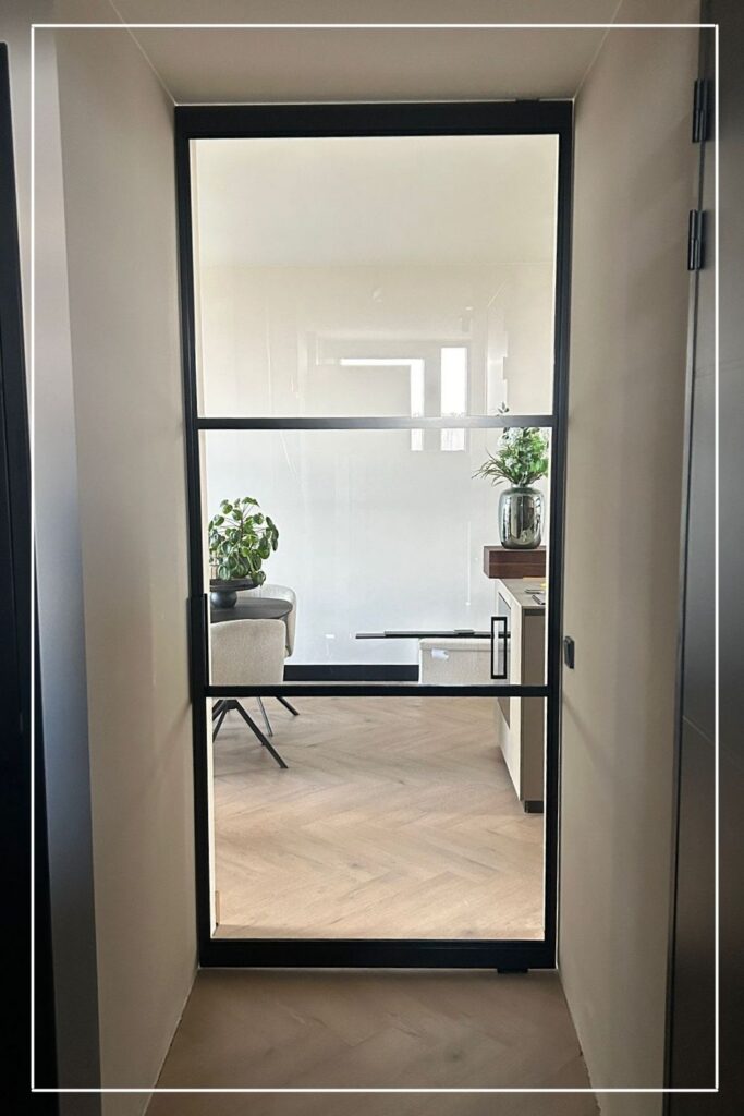 Zwarte stalen taatsdeur Classic model No. 3 met helder glas van Skygate in een hal