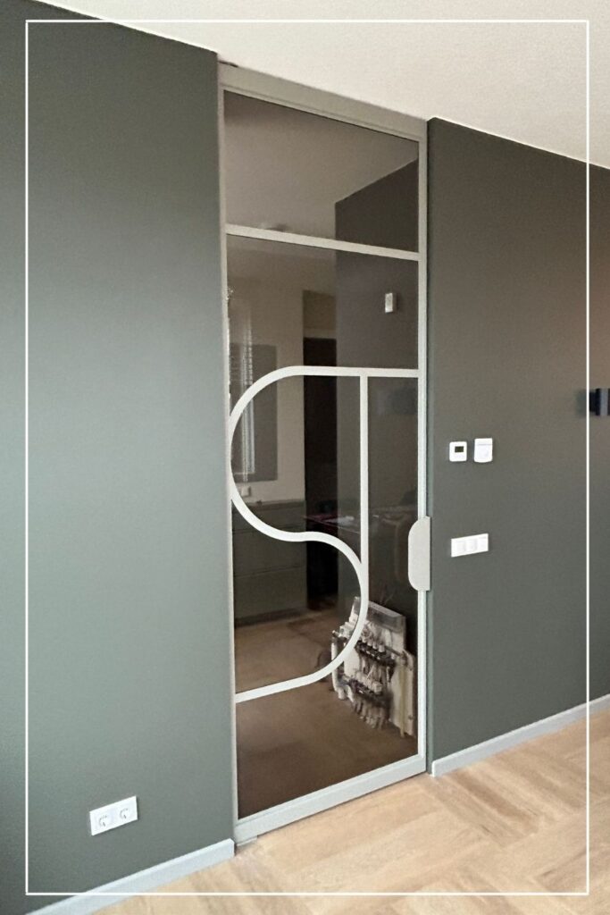 Witte stalen taatsdeur met eigen design en glas van Skygate in een modern interieur
