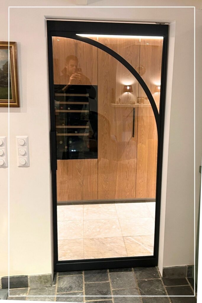 Zwarte stalen taatsdeur met eigen design en helder glas van Skygate in een luxe interieur