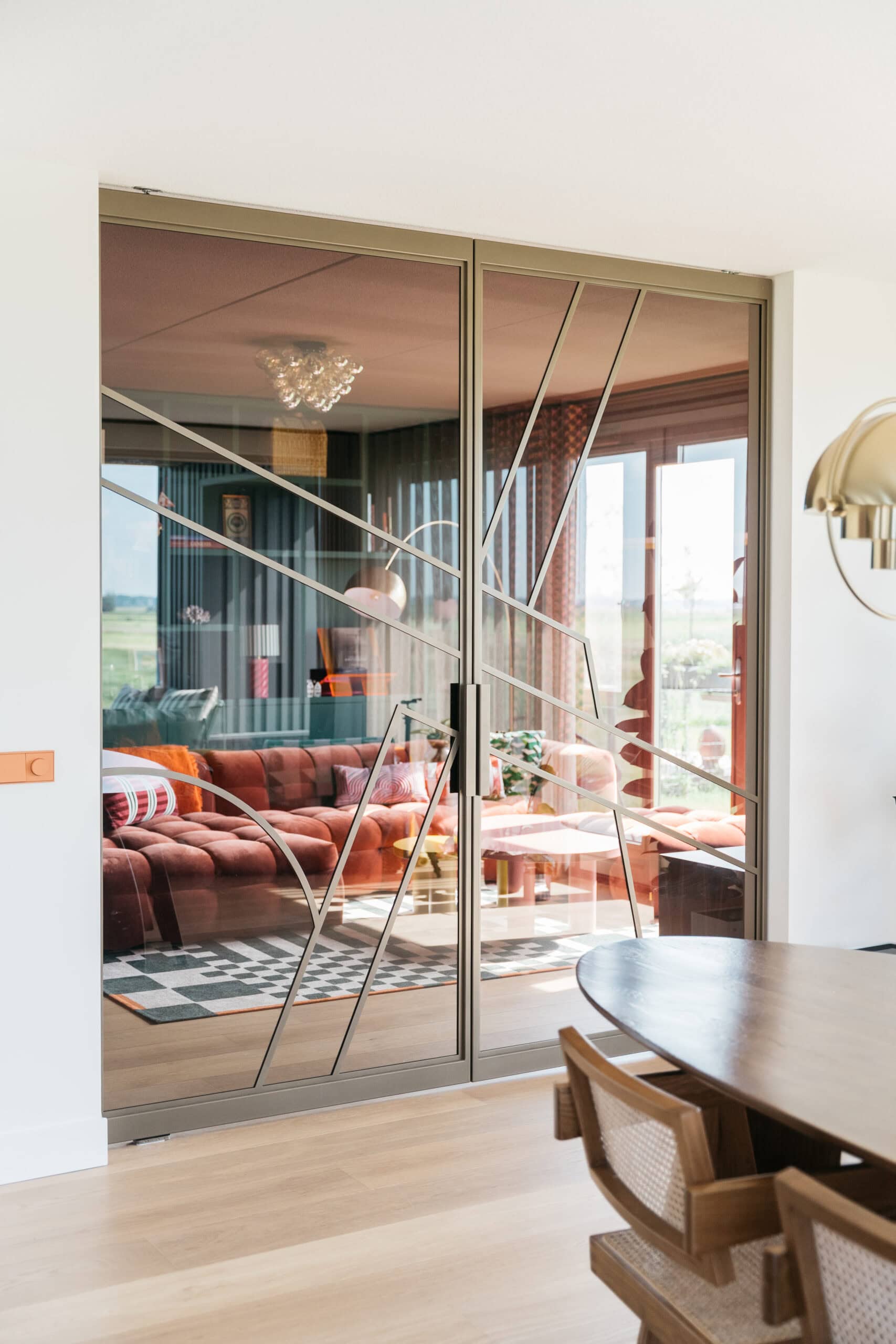 Skygate taatsdeuren op maat in metallic brown met ribglas en Flow design tussen hal en woonkamer