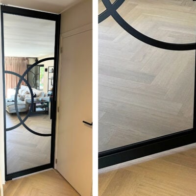 Stalen taatsdeur met rookglas en zwart frame in een modern interieur.